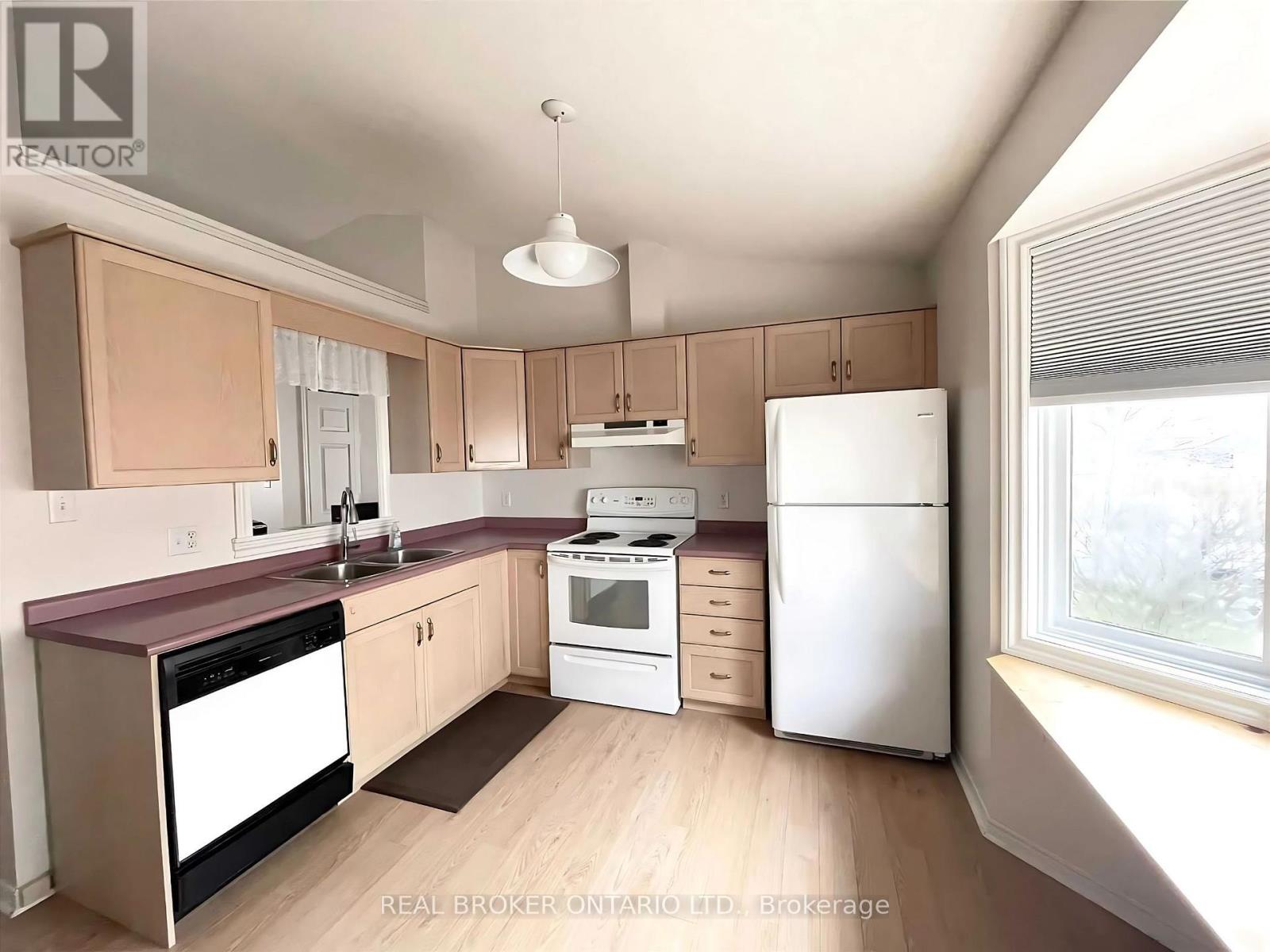 A kitchen with a white refrigerator, a white stove, and a white dishwasher.