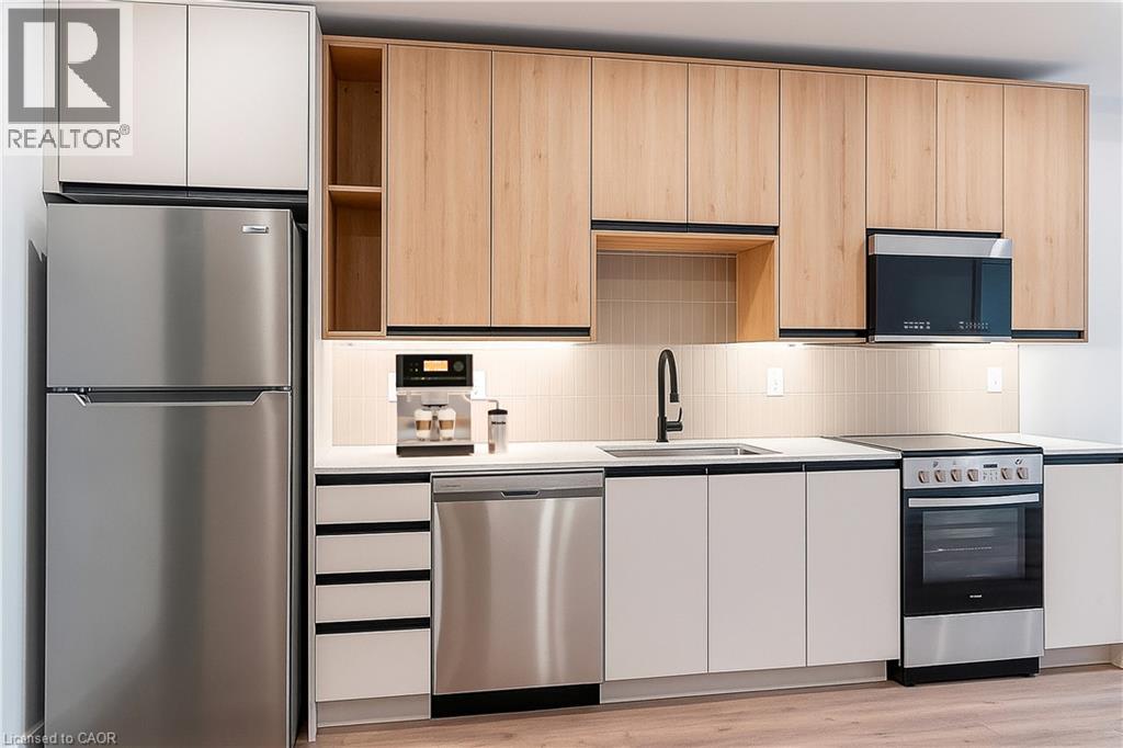 A modern kitchen with a stainless steel refrigerator and wooden cabinets.