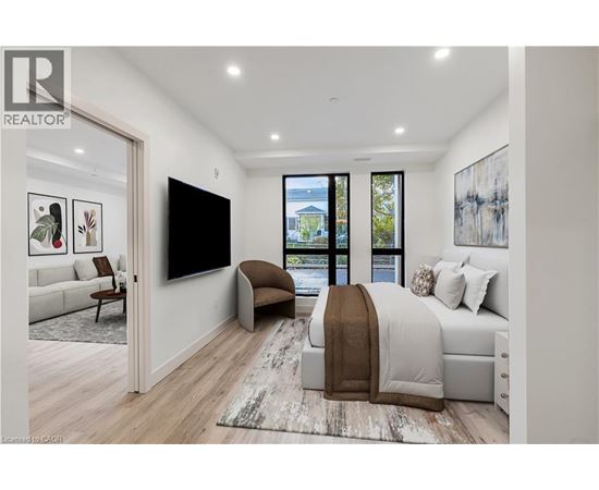 A bedroom with a large bed and a flat screen TV mounted on the wall.
