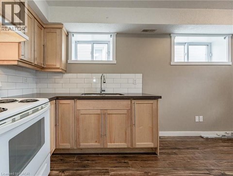 A kitchen with wooden cabinets and a white stove top oven.