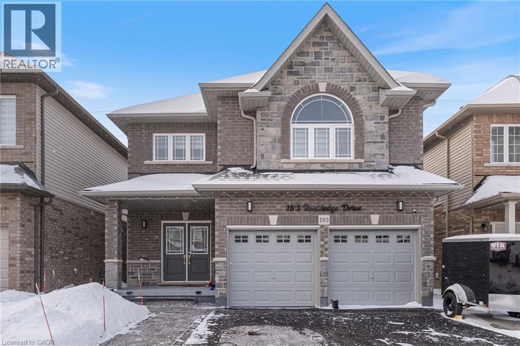 A house with a garage and a driveway in front.
