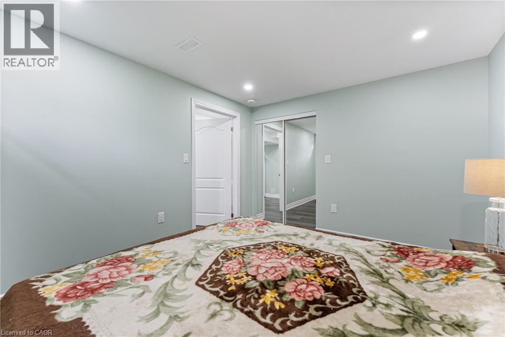 A bedroom with a floral bedspread and a mirror on the wall.