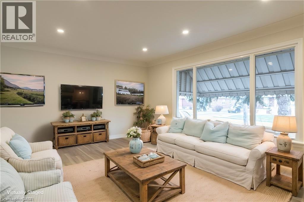 A living room with a white couch, a wooden coffee table, and a flat screen TV mounted on the wall.
