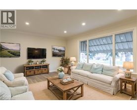 A living room with a white couch, a wooden coffee table, and a flat screen TV mounted on the wall.