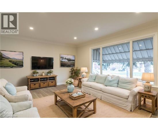 A living room with a white couch, a wooden coffee table, and a flat screen TV mounted on the wall.