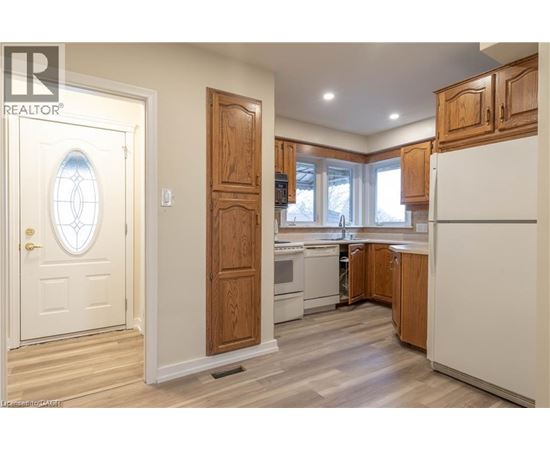 A kitchen with wooden cabinets and a white refrigerator.