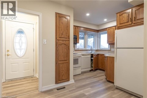 A kitchen with wooden cabinets and a white refrigerator.