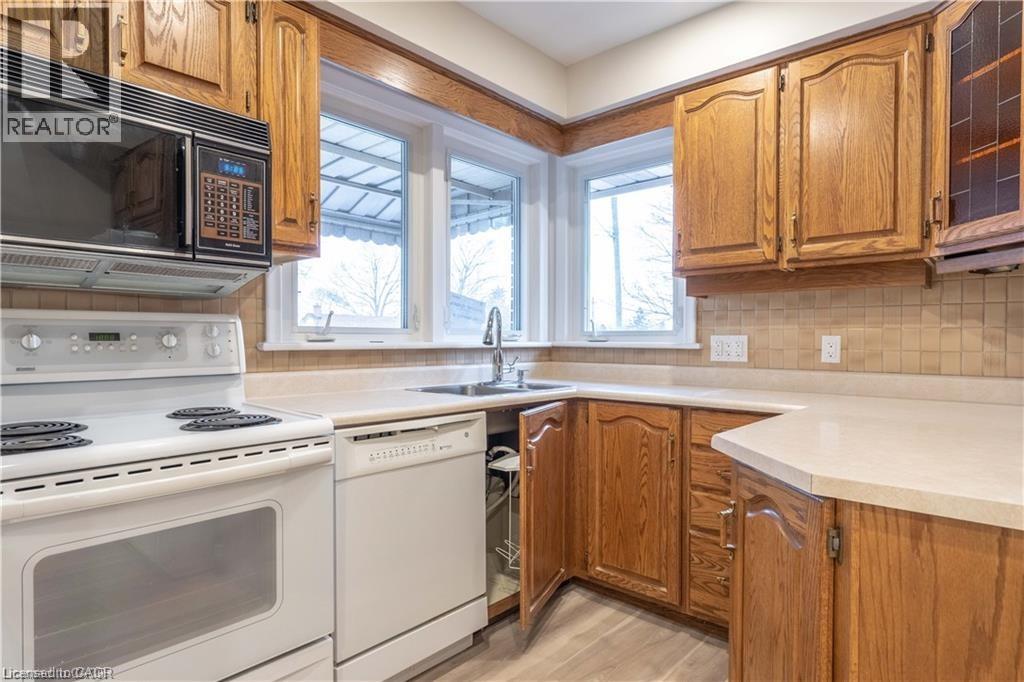 A kitchen with wooden cabinets and white appliances.