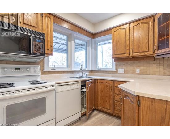 A kitchen with wooden cabinets and white appliances.