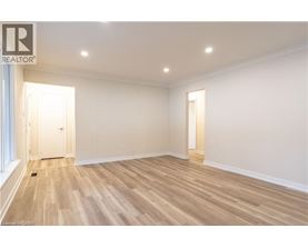 A spacious room with wooden flooring and white walls.