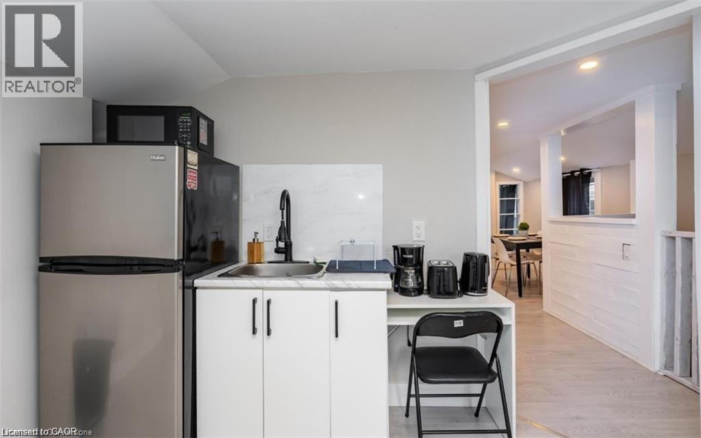 A kitchen with a refrigerator, microwave, and a sink.