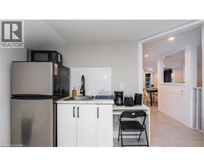 A kitchen with a refrigerator, microwave, and a sink.