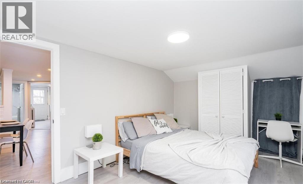 A bedroom with a bed, nightstand, and chair.