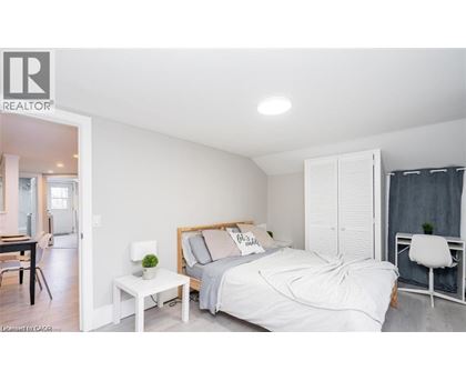 A bedroom with a bed, nightstand, and chair.