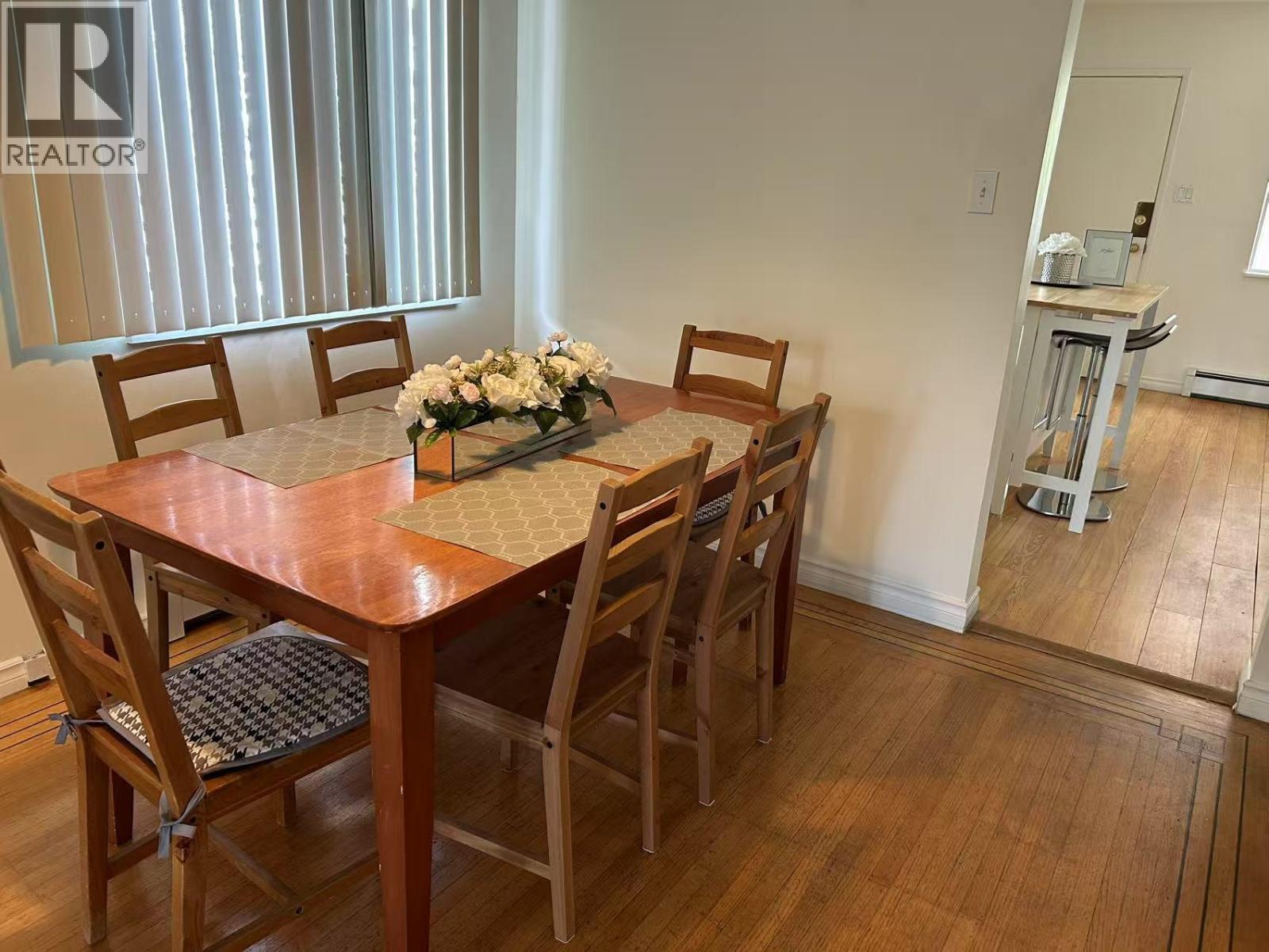 A dining room with a wooden table and chairs.