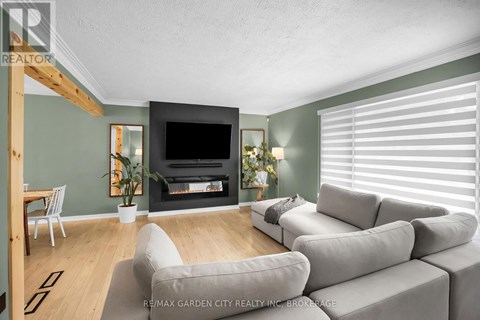 A living room with a grey sofa and a fireplace.
