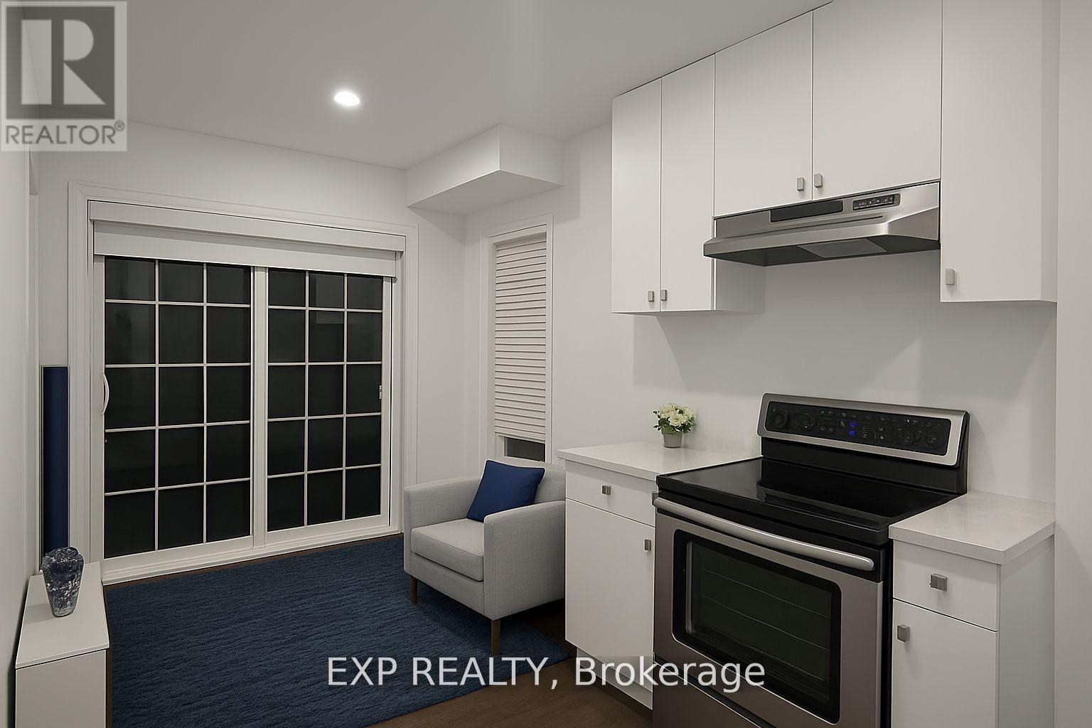 A modern kitchen with white cabinets and a black stove top oven.