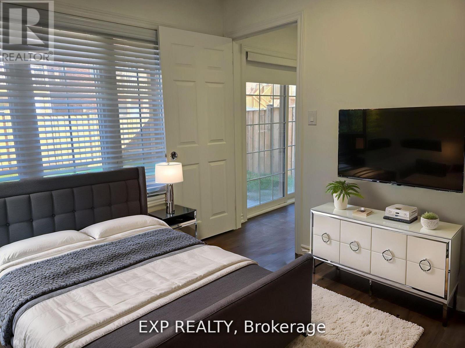 A bedroom with a bed, nightstand, and dresser.