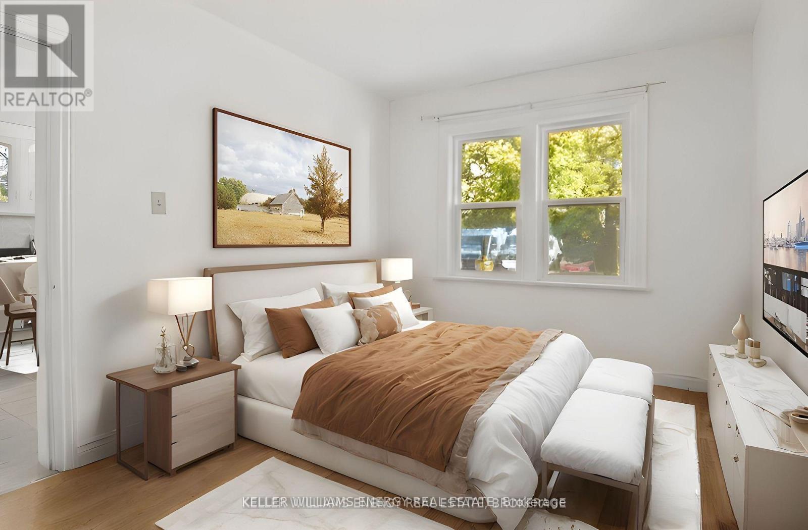 A bedroom with a large bed and a painting on the wall.