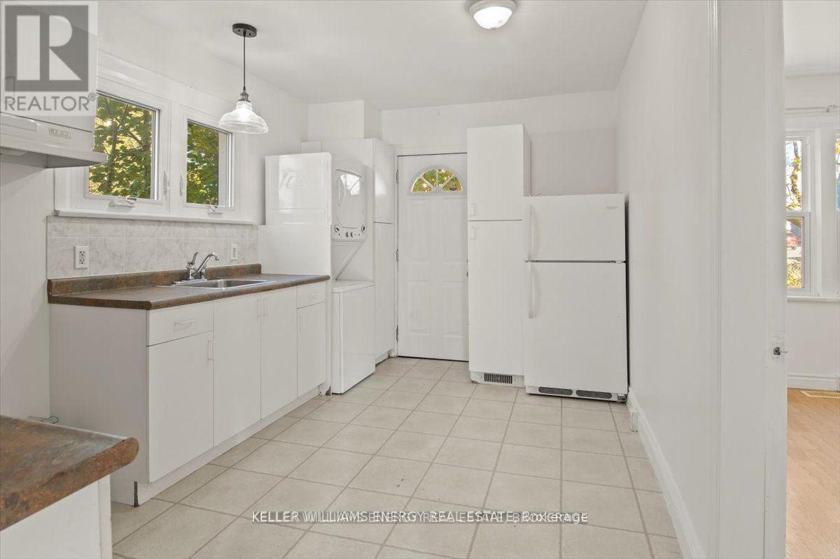 A kitchen with white cabinets and appliances.