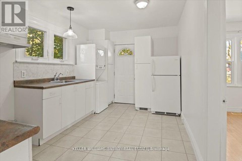 A kitchen with white cabinets and appliances.