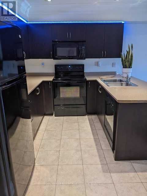 A kitchen with black cabinets and a black stove top oven.