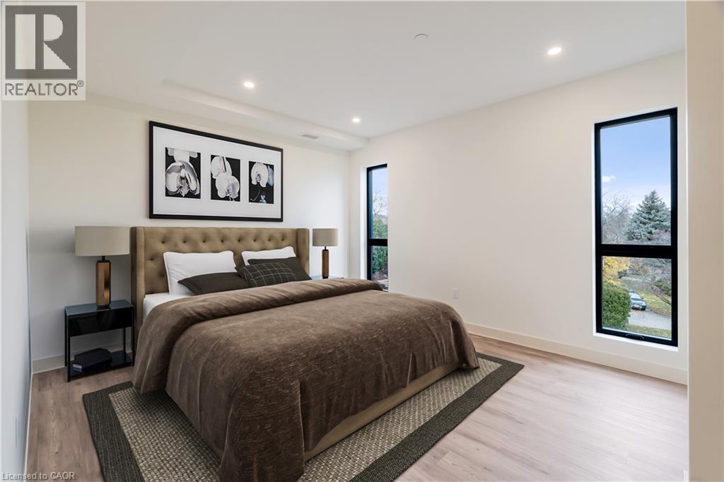 A bedroom with a large bed and a framed picture on the wall.