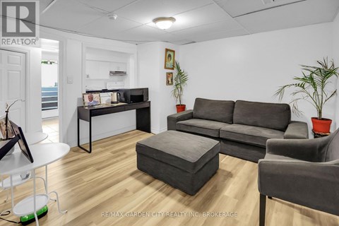 A living room with a grey couch and a white table.