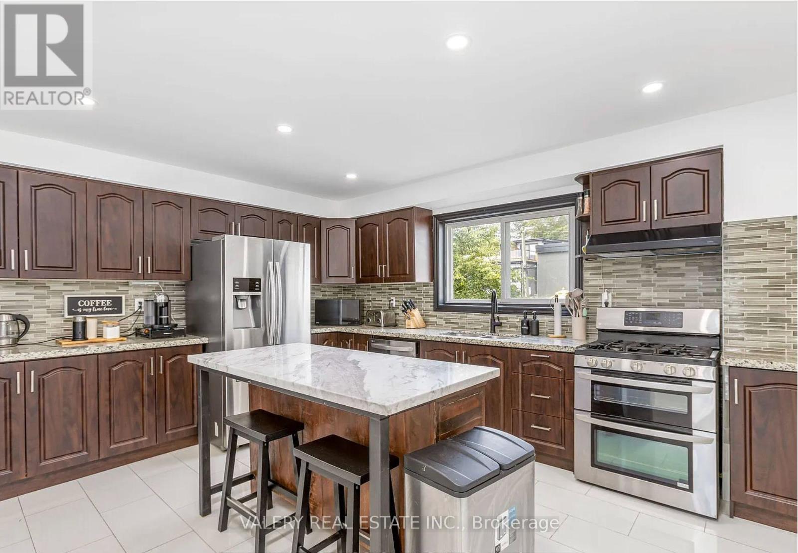 A modern kitchen with dark wood cabinets and stainless steel appliances.