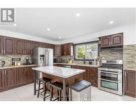 A modern kitchen with dark wood cabinets and stainless steel appliances.