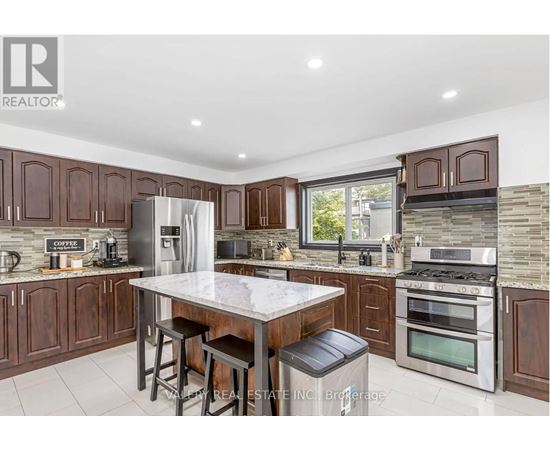 A modern kitchen with dark wood cabinets and stainless steel appliances.