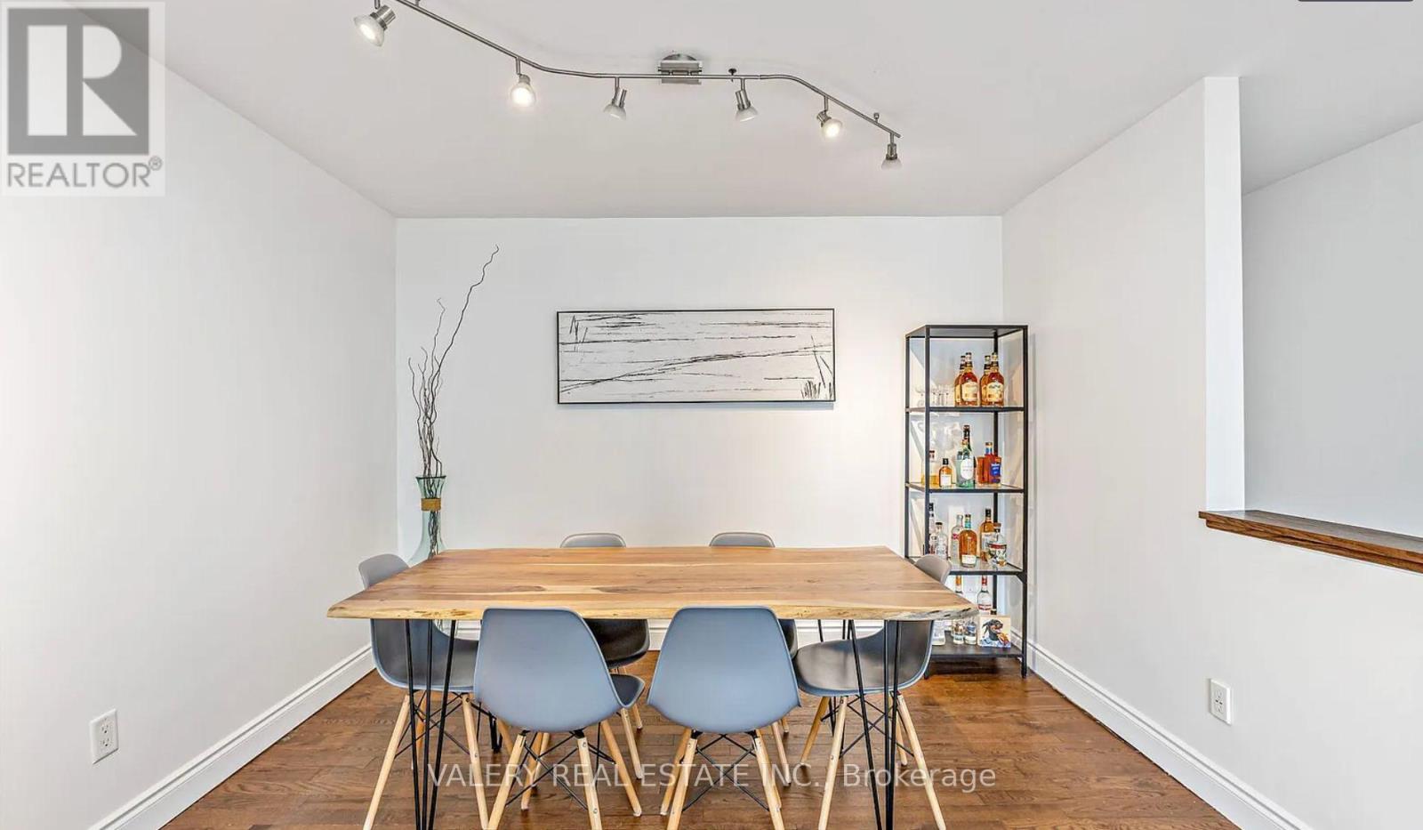 A dining room with a wooden table and chairs.
