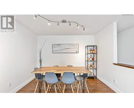 A dining room with a wooden table and chairs.