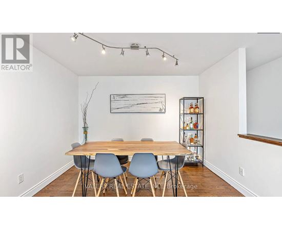A dining room with a wooden table and chairs.