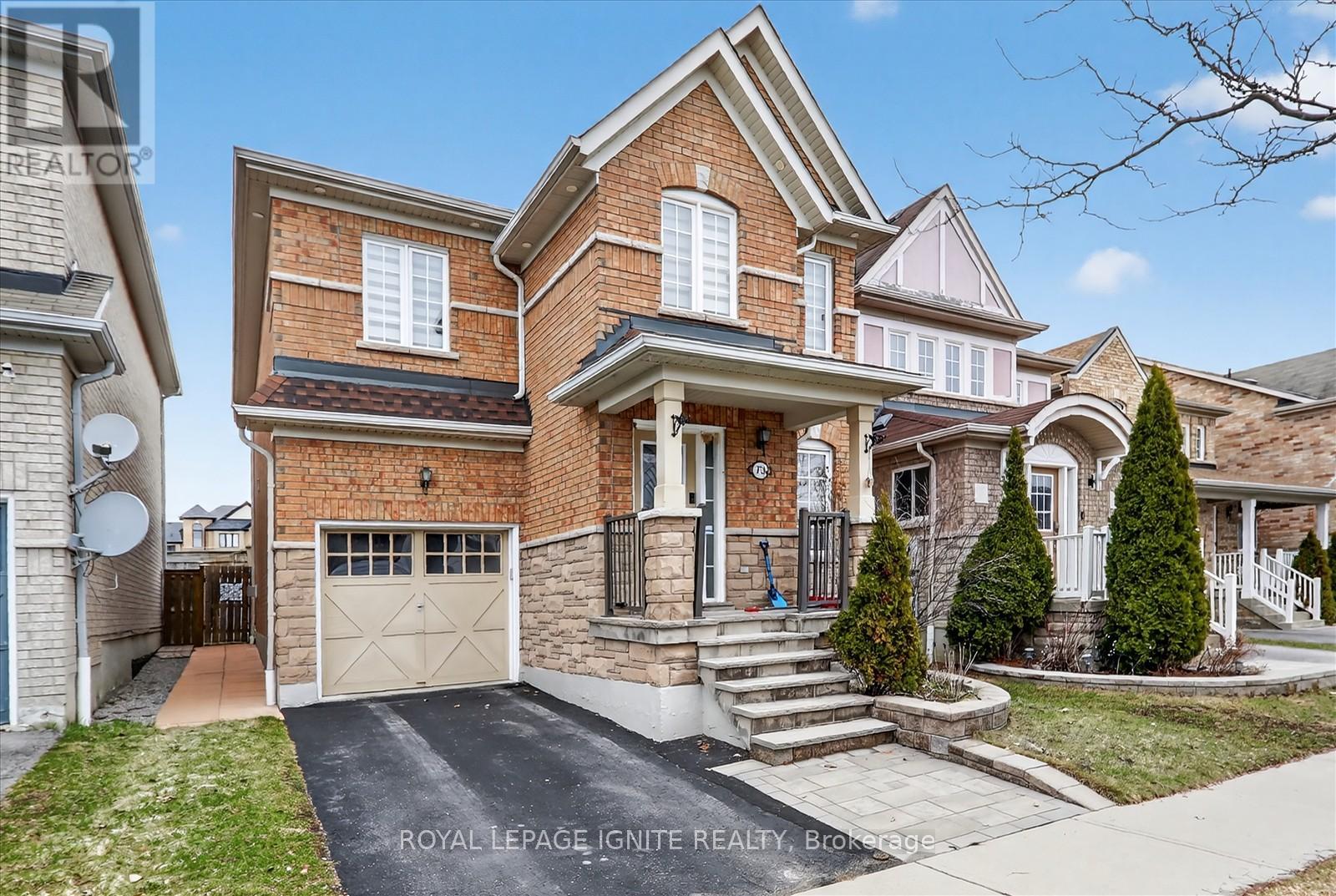 A house with a brick facade and a white garage door is for sale.