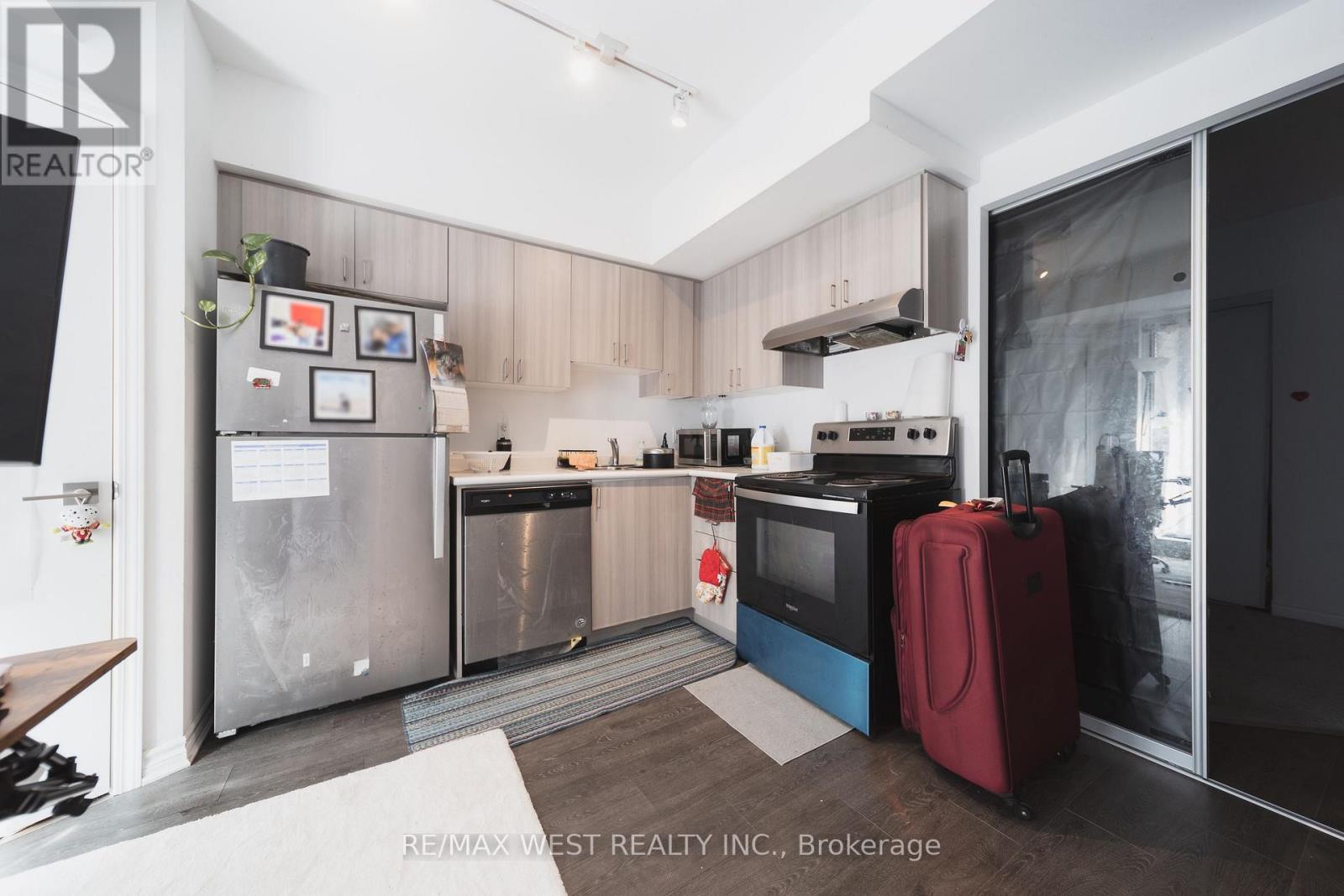 A kitchen with a refrigerator, oven, and microwave.
