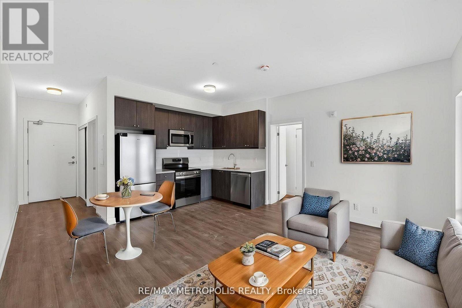 A modern living room with a dining area and kitchen in the background.