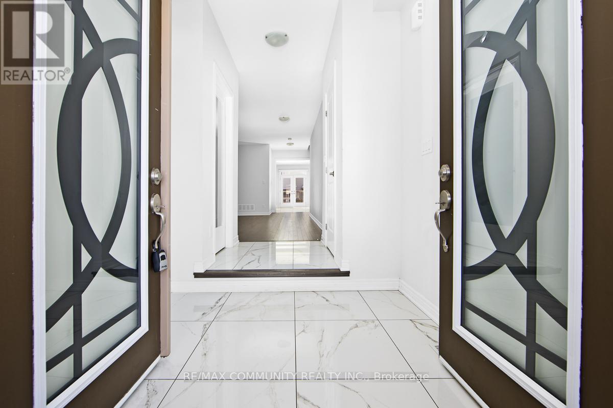 A hallway with a glass door and a marble floor.