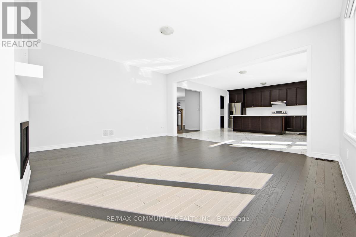 A spacious living room with a television and a rug on the floor.