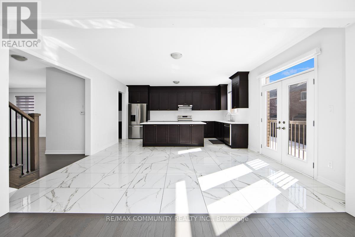 A spacious kitchen and living room with white marble flooring and black cabinetry.