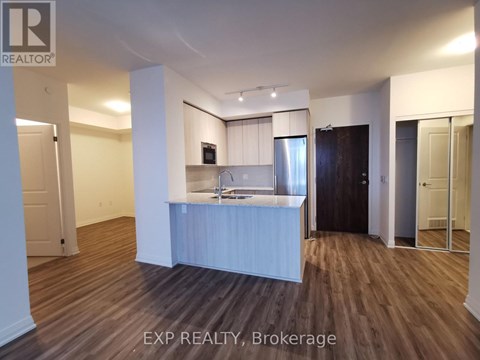 A kitchen area with a refrigerator, microwave, and oven.