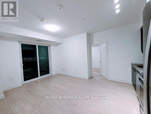A spacious room with a sliding glass door and a wooden floor.