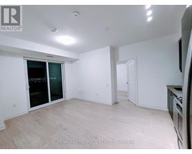 A spacious room with a sliding glass door and a wooden floor.