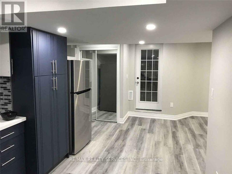 A kitchen with dark blue cabinets and a refrigerator.