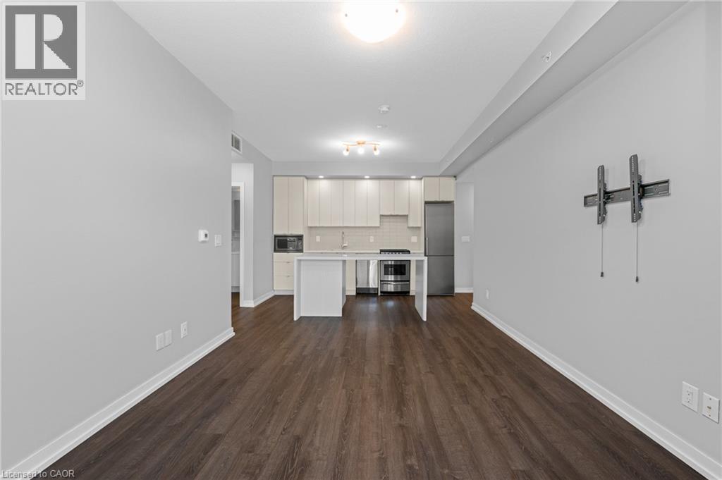 A spacious room with wood flooring and white walls.