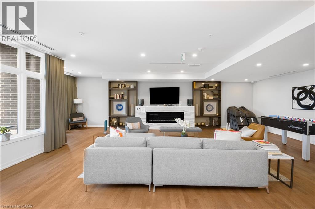 A modern living room with a grey sofa and a pool table.