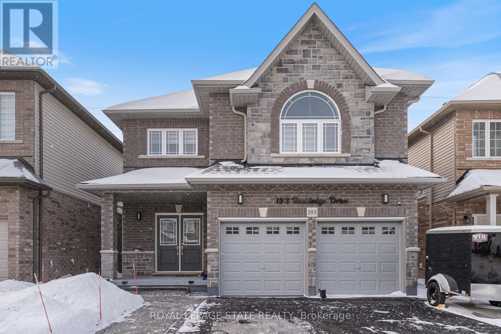 A house with a garage and a driveway in front of it.