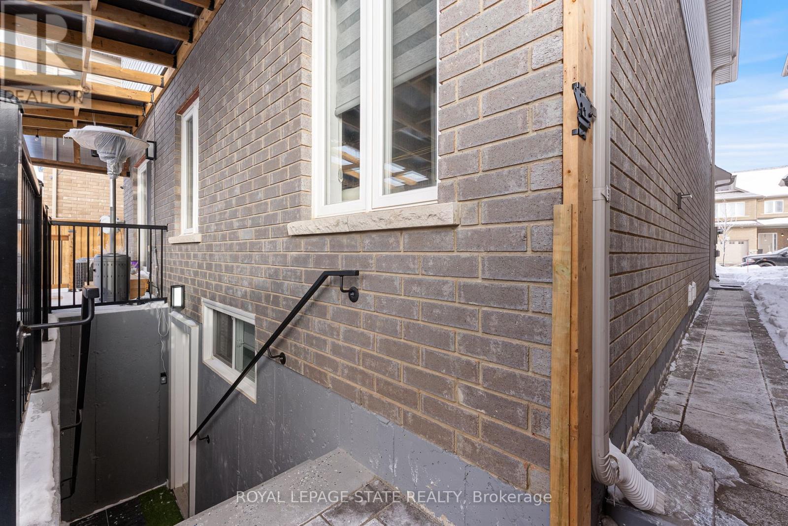 A brick building with a black railing and a window.