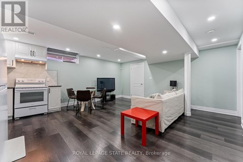 A living room with a red table and a television.