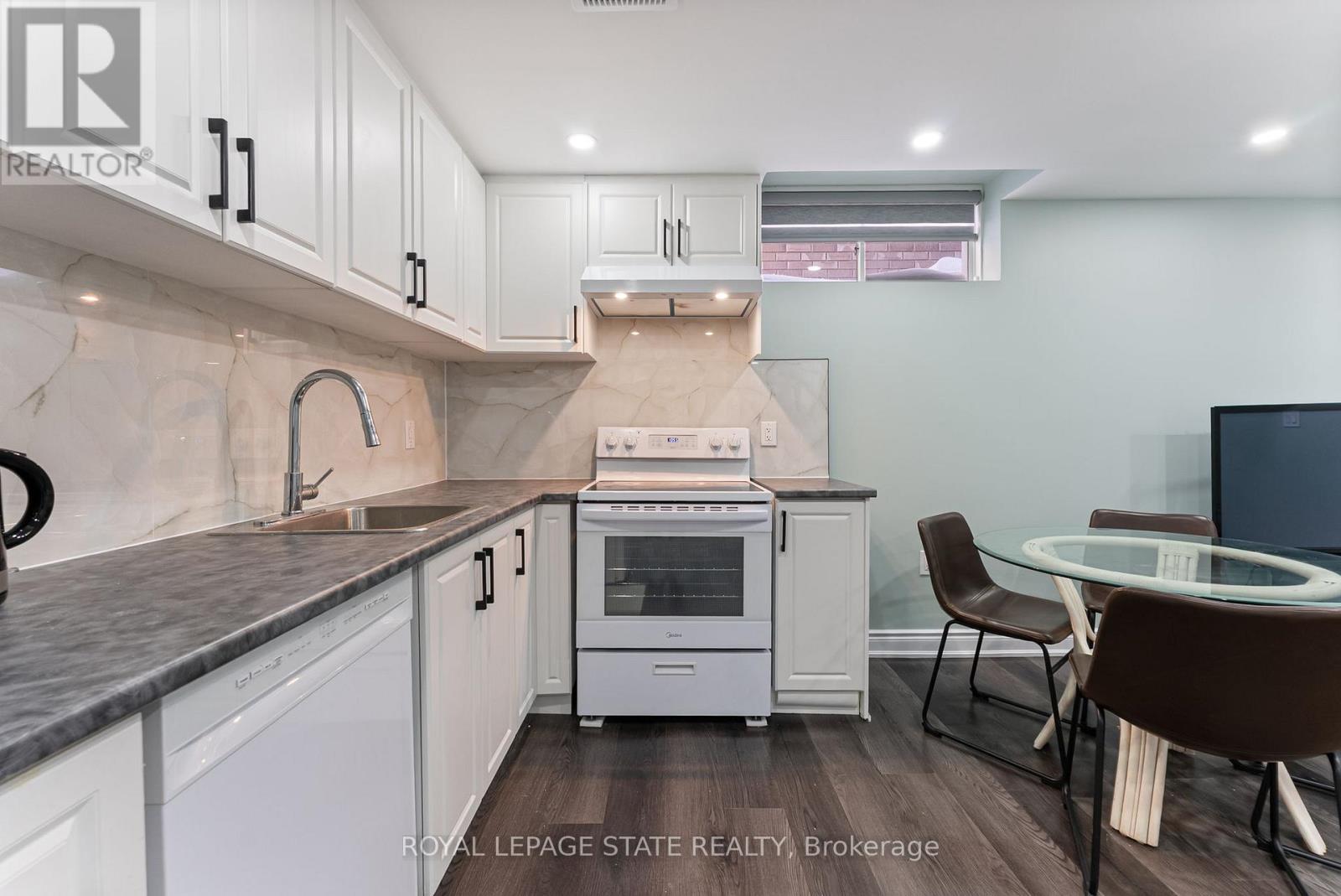 A modern kitchen with white cabinets and a stainless steel oven.